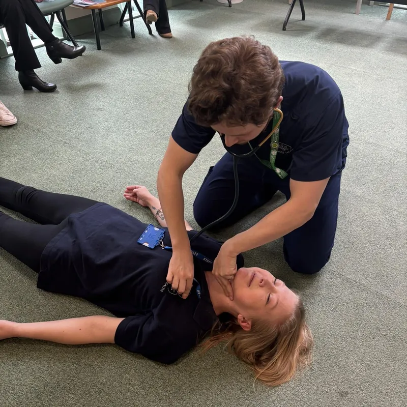 Checking a casualty lying on the floor during a practical session
