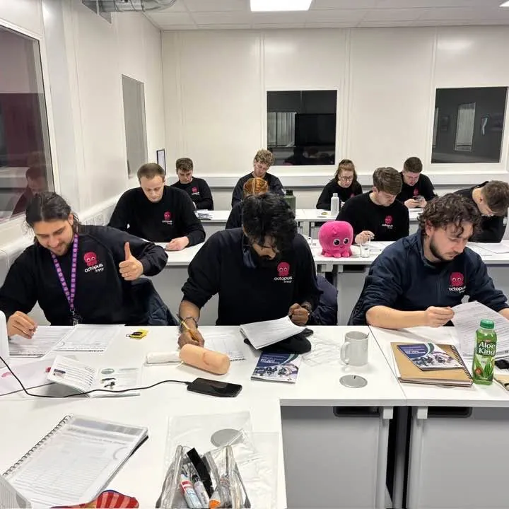 A classroom session with course workbooks on the desks