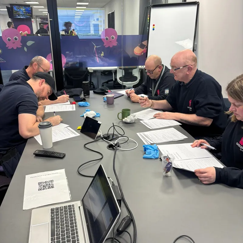 Delegates working through course paperwork around a table