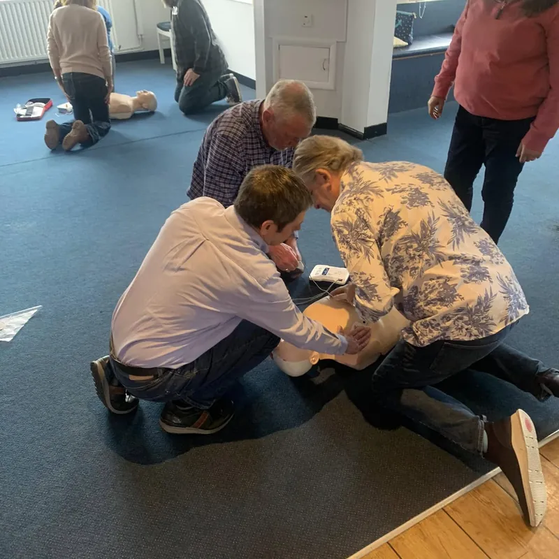 Pairs practising CPR on manikins