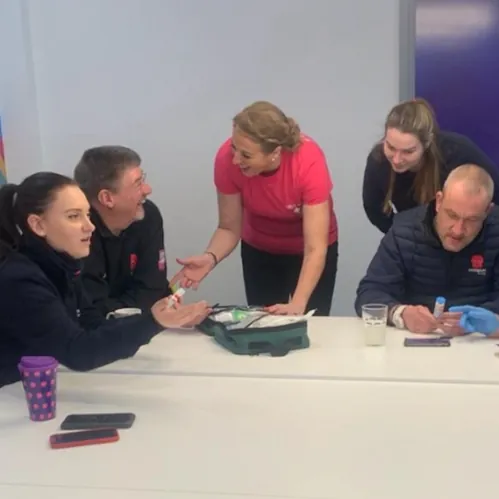 A trainer talking a group through a first aid kit