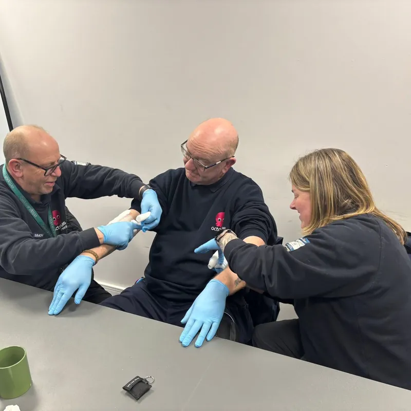 Delegates practising with protective gloves at a table