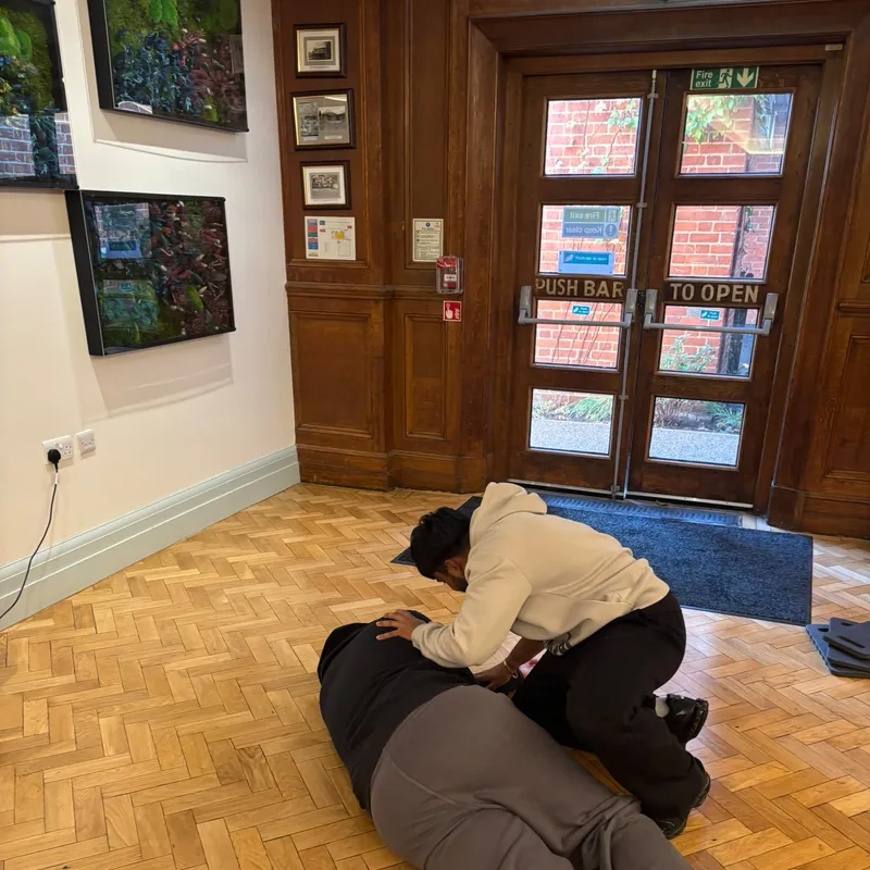 Placing a volunteer casualty in the recovery position by the hall doors