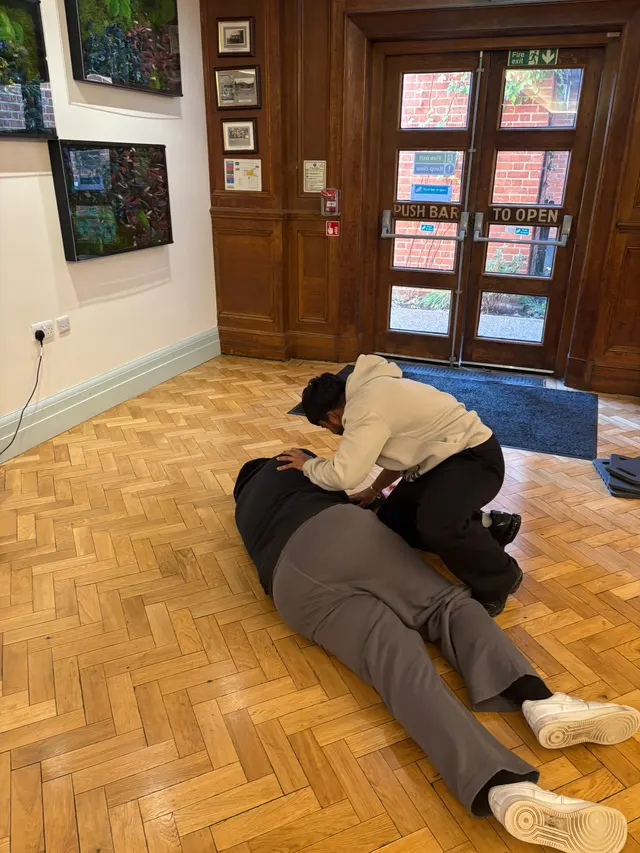Placing a volunteer casualty in the recovery position by the hall doors