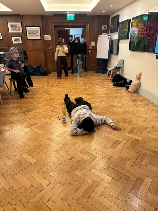 A volunteer lying face down as the casualty in a practical scenario