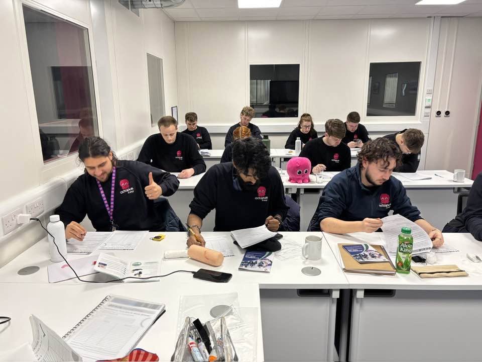 A classroom session with course workbooks on the desks